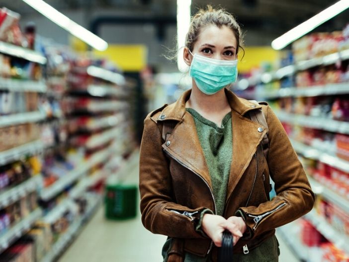 young women socially distancing while wearing a mask in a grocery store